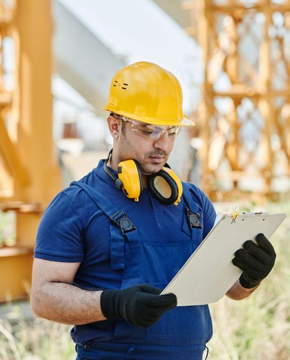 Técnico de capacete fazendo o levantamento de riscos na obra