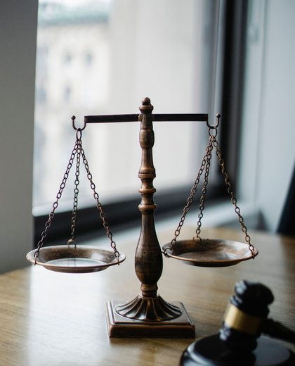 Balança da justiça e martelo sobre a mesa de um escritório de advocacia