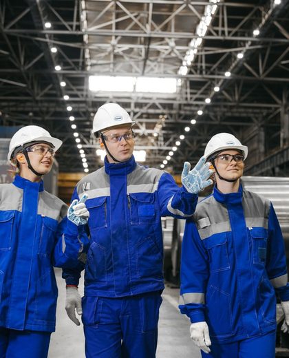 Equipe de indústria com capacete, óculos e uniforme de proteção no galpão