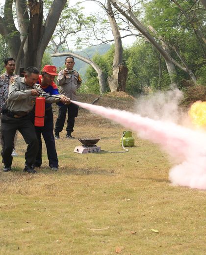 Equipe em treinamento prático apagando fogo com extintor
